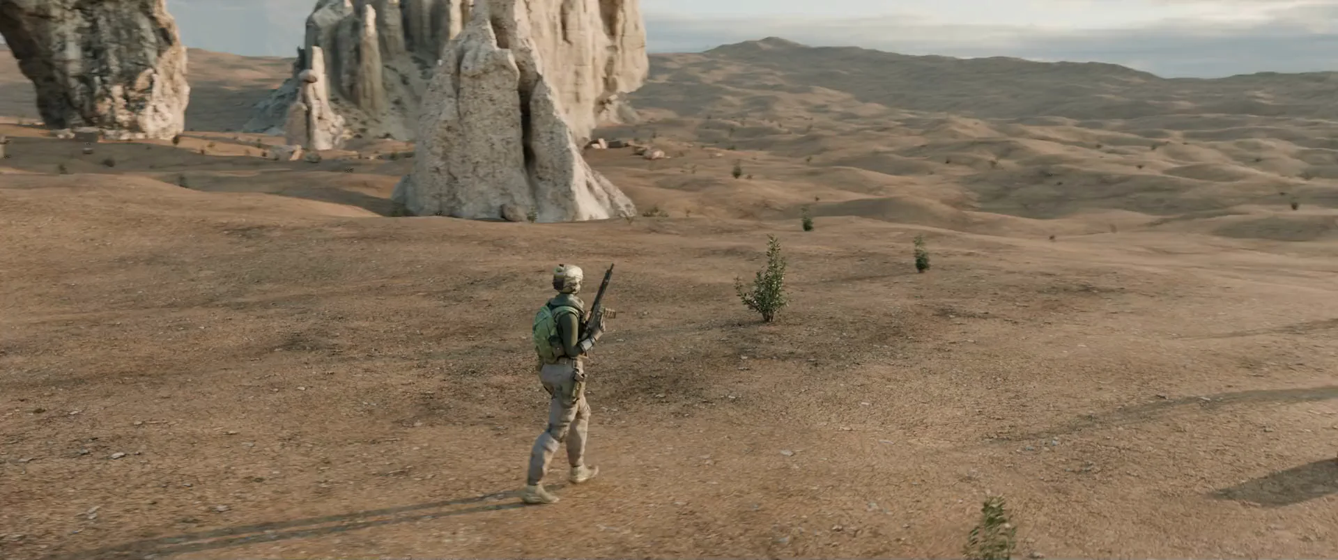 Odd Terrain: a soldier walks across a desert of pale rock towers, the camera sweeping round to her front.